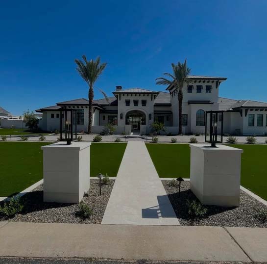 Sleek masonry columns border a central paver entry path