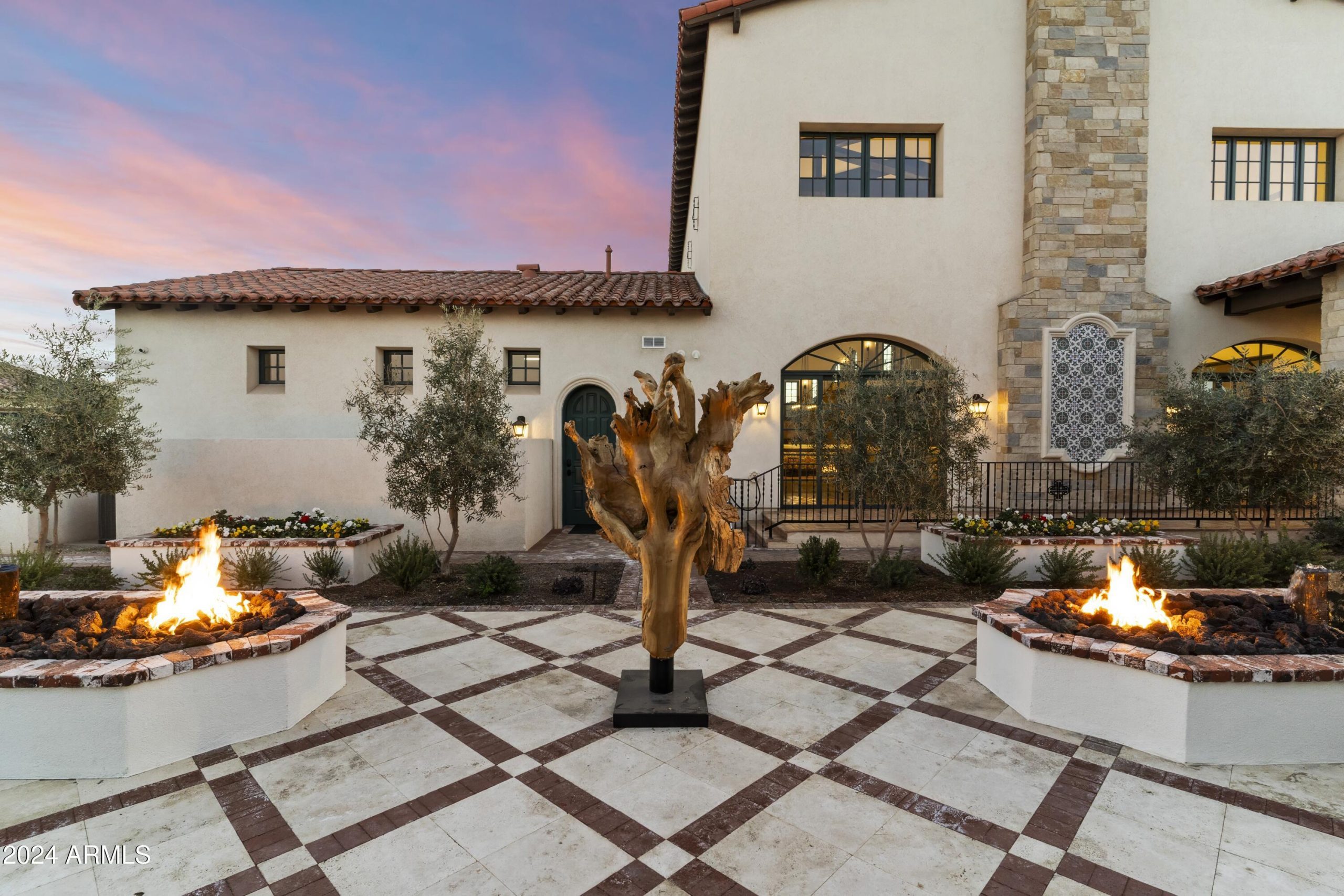 Ornate diamond pattern stone paver patio with twin fire features